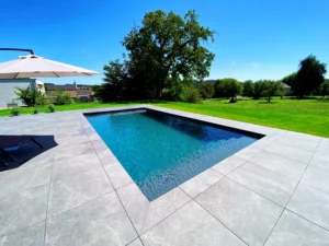 Photo retravaillée-définitive Piscine en béton sur carrelage gris