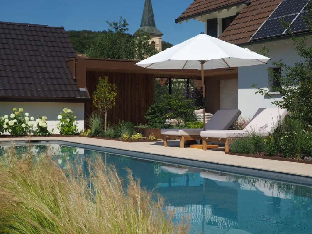 Construction d'une piscine miroir à Oltingue dans le Haut-Rhin avec salon de jardin et végétalisation